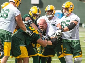 Members of the Edmonton Eskimos break up a scuffle between offensive lineman Justin Sorensen, right, and defensive tackle Eddie Steele during practice at Commonwealth Stadium on Tuesday. (Robert Murray)