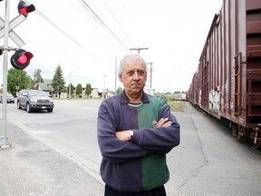 Frank Mazzuca Jr. stands at the level crossing in Capreol at which trains have been holding up traffic for more than 25 minutes. on Tuesday June 7, 2016. Gino Donato/Sudbury Star/Postmedia Network