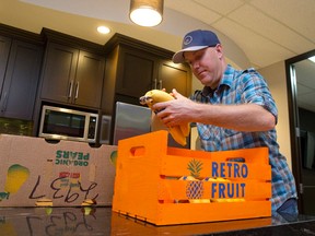 Matt McClintock sorts through a box of fresh, organic fruit as he delivers healthful snacks to the CarProof office kitchen as part of his food delivery service. (CRAIG GLOVER, The London Free Press)