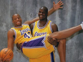 In this Oct. 14, 1996, file photo, Los Angeles Lakers­ Shaquille O’­Neal holds up fellow centre Sean Rooks as they pose for a picture at Lakers­ Media Day at the Forum in Inglewood, Calif. (AP Photo/Chris Pizzello, File)