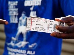 Montez Jones shows off his tickets to Muhammad Ali’s memorial service Friday at the KFC Yum! Center after waiting in line Wednesday, June 8, 2016, in Louisville, Ky. (AP Photo/David Goldman)