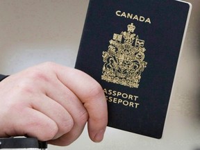 A passenger holds a Canadian passport before boarding a flight in Ottawa on Jan 23, 2007. Federal officials used photo-matching technology to identify 15 high-risk people - all wanted on immigration warrants - who used false identities to apply for travel documents. THE CANADIAN PRESS/Tom Hanson