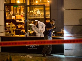 Israeli police officers examine the scene of a shooting attack in Tel Aviv, Israel, Wednesday, June 8, 2016. Two Palestinian gunmen opened fire in central Tel Aviv Wednesday night, killing three people and wounding at least five others, Israel police said. (AP Photo/Sebastian Scheiner)