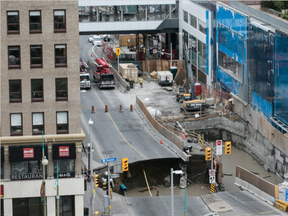 A large portion of Rideau Street in downtown Ottawa, Ontario is seen caved in, causing a massive sinkhole that caused disruptions in the downtown area on June 8, 2016. (Chris Roussakis/AFP)