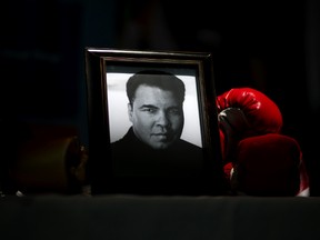 A portrait of Muhammad Ali is displayed next to a pair of boxing gloves at the I Am Ali Festival at the Kentucky Center for the Performing Arts Wednesday, June 8, 2016, in Louisville, Ky. Ali's memorial service Friday looms as one of the most historic events in Louisville's history. (AP Photo/David Goldman)
