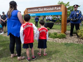 (left to right ) Cst. Dan Woodall's wife and sons Claire Woodall, Gabe Woodall and Callen Woodall watch as the sign to Const. Dan Woodall Park, 7304 South Terwillegar Drive NW, is unveiled in Edmonton Alta. on Wednesday June 8, 2016. Edmonton Police Service Const. Daniel Woodall was killed in the line of duty on June 8, 2015. Photo by David Bloom
