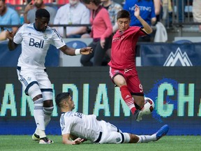 Ottawa Fury FC's Bryan Olivera, right, has the ball taken away by Vancouver Whitecaps' Matias Laba, bottom, as Jordan Smith, left, watches during Canadian championship soccer action on June 8. (THE CANADIAN PRESS/Darryl Dyck)