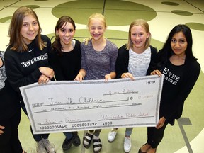 Sudhershi Kularatnam from Free The Children/WE Day headquarters, right  accepts a cheque from Grade 6 teacher Stacey Gianfrancesco, Shannon Clarke, Anna Teolis, Meredith Kusniercyzk, and  Anne-Marie Sakki at Alexander Public School  in Sudbury, Ont. on Wednesday June 8, 2016. The Grade 8 students  achieved their goal of raising $10,000 to build a school in Ecuador by the time they graduate from Alexander Public School. Missing from the photo is Bradie Roy. Gino Donato/Sudbury Star/Postmedia Network