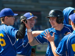 Windsor St. Anne Saints pinch-runner Mitchell Zimmerman celebrates with teammates after scoring a run early in their OFSAA boys championship baseball game against Toronto Bishop Allen Cardinals at Labatt Park on Wednesday. For the second time in three years, the Saints defeated Bishop Allen for the gold medal with a 4-2 win. (CRAIG GLOVER, The London Free Press)