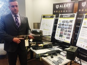 Alberta Law Enforcement Response Teams Staff Sgt. Dave Knibbs with some of the firearms seized after a lengthy investigation into the Edmonton chapter of the Hells Angels motorcycle club that resulted in 10 arrests. Photo taken at an ALERT press conference on June 8, 2016. Photo by Paige Parsons