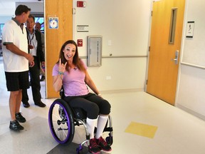 Amy Van Dyken-Rouen gestures as she leaves Craig Hospital with her husband, Tom Rouen, left, in Englewood, Colo. (AP Photo/Brennan Linsley, File)