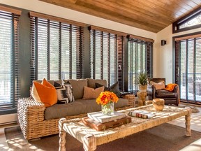 Large double-glazed windows and sliding doors embrace views of the 
lake and forest, and wood blinds can be adjusted for incoming light.