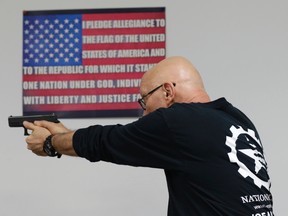 Mike Weinstein, director of training and security at the National Armory gun store and gun range, shows how to safely fire a Glock 9mm hand gun during a Concealed Weapons Permit class on Tuesday, Jan. 5, 2016, in Pompano Beach, Fla. (AP Photo/Lynne Sladky)