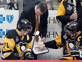 In this May 30, 2016, file photo, Pittsburgh Penguins' Sidney Crosby talks with Pittsburgh Penguins head coach Mike Sullivan and Evgeni Malkin during a timeout in the third period in Game 1 of the Stanley Cup final series against the San Jose Sharks, in Pittsburgh. (AP Photo/Gene J. Puskar, File)