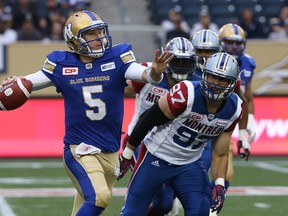Winnipeg Blue Bombers QB Drew Willy throws up a pass under pressure from Montreal Alouettes DE Aaron Lavarias during CFL action on Wednesday. (Kevin King/Winnipeg Sun)