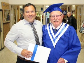 Ryan Bedard from Sarnia Collegiate Institute and Technical School (SCITS) hands a diploma to Reginald Learn in the hallways of SCITS on Thursday June 9, 2016 in Sarnia, Ont. The 84-year-old former student is returning to finish his diploma and he graduated with the final SCITS class. Terry Bridge/Sarnia Observer/Postmedia Network