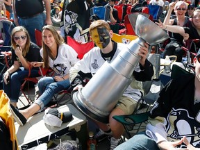Zachary Sheeler, of Johnstown, Pa., holds a fake Stanley Cup as he waits with Pittsburgh Penguins fans to watch Game 5 of the Stanley Cup final between the Penguins and the San Jose Sharks on a big screen in front of the Consol Energy Center in Pittsburgh on Thursday, June 9, 2016. (Keith Srakocic/AP Photo)