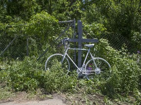 A ghost bike is displayed as a memorial Wednesday, June 8, 2016, in Cooper Township, Mich., where five bicyclists were killed and four were injured by an oncoming vehicle. (Tom Brenner/The Grand Rapids Press via AP)