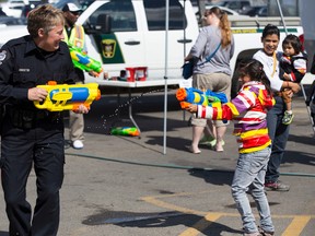 Noemi, 9, and EPS Cst. Amanda Trenchard, from West Division, play with squirt guns during Free The Fuzz at the South Edmonton Common Walmart in 2014. Free The Fuzz is a fundraiser for Special Olympics Alberta.