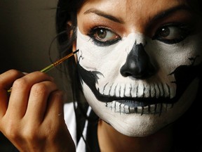 Luke Hendry/The Intelligencer
Makeup artist and body painter Melissa Brant applies a skull design to her face while working at home in Corybville. She spends hours experimenting with new designs, often testing new looks on herself.