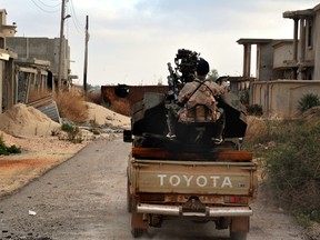 In this March 7, 2016 file photo, a man loyal to the Libyan armed forces prepares himself for clashes with Islamic State group militants west of Benghazi, Libya. (AP Photo/Mohammed el-Shaiky, File)