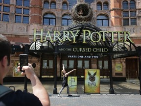 A tourist poses for a picture in front of the Palace Theatre as it promotes its new show 'Harry Potter and the Cursed Child'  in London on June 6, 2016.
Harry Potter makes his stage debut on June 7 in a new London play that imagines the fictional boy wizard as a father of three, in the latest offshoot of the globally successful franchise. / AFP PHOTO / DANIEL LEAL-OLIVAS /