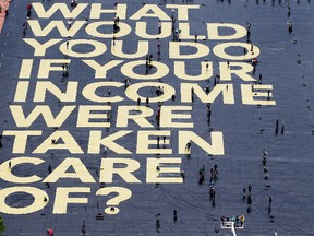 A huge poster reading “What would you do if your income were taken care of?” is pictured on the Plaine de Plainpalais square in Geneva, Switzerland. (File photo)