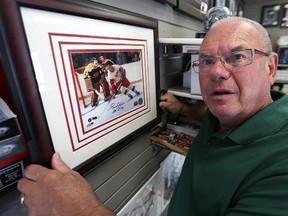Joe Daley checks out a framed and autographed picture of Gordie Howe at Joe Daley's Sports & Framing on St. Mary's Road. (Kevin King/Winnipeg Sun)
