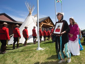 Sylvia Arcand carries a portrait of her late husband Corporal Ray Arcand during the grand opening of the new Enoch RCMP Detachment, Highway 60 and Township 523, on the Enoch Cree Nation Alta. on Friday June 10, 2016. The portrait of Corporal Ray Arcand will be displayed within the new detachment. DAVID BLOOM/POSTMEDIA NEWS NETWORK