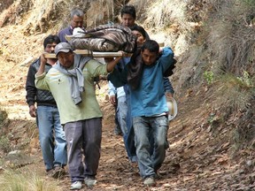 Local residents carry the corpse of one of the eleven members of a family shot dead at El Mirador village in Coxcaltlan, Puebla state, Mexico, on June 10, 2016. 
Gunmen marched into a remote mountain village in Mexico on Friday and killed 11 members of the same family, including two children, authorities said. (AFP PHOTO/SAUL MUNOZ)