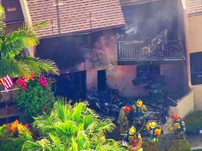In this still frame from video provided by KABC-TV, firefighters work the scene where a small plane crashed into a multifamiy building in the Los Angeles suburb of Hawthorne, Calif., Friday afternoon, June 10, 2016. Early reports indicated two people aboard the plane died. No injuries were reported on the ground. (KABC-TV via AP)