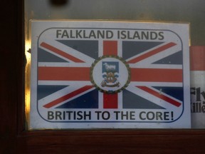 A sign with the Union Jack flag and the words "Falkland Islands - British to the core!" is seen on a store window in Port Stanley March 15, 2012. Thirty years after the Falklands War, patriotism is again running high on the islands as Argentina tries to pressure Britain to negotiate their sovereignty. In the quiet island capital of Stanley, Union Jack flags and red, white and blue bunting are selling fast, and police are urging Argentine visitors - most of them veterans of the 1982 war - not to antagonize locals by waving their own national flag. Picture taken March 15, 2012.  REUTERS/Marcos Brindicci