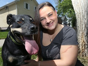 Katie Powell poses with Dooley outside her St. Boniface home where she runs the Save-A-Dog Network as a volunteer on Thu., June 9, 2016. Powell has adopted four dogs, including Dooley, who has just three legs and one kidney. (Kevin King/Winnipeg Sun/Postmedia Network)