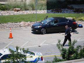 An investigator works the scene of an officer-involved shooting which prompted a lockdown at Dallas Love Field airport Friday, June 10, 2016, in Dallas.  (Tom Fox/The Dallas Morning News via AP)