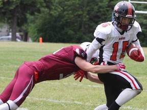 Ottawa Myers Rider Owen Clement dodges a tackles from Limestone District Grenadiers William Keneford during the senior game of Varisty football on Saturday June 11, 2016 at Loyalist Collegiate and Vocational Institute in Kingston. Steph Crosier, Kingston Whig-Standard, Postmedia Network