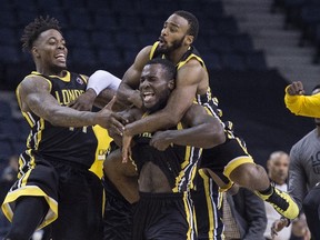 London Lightning, from left to right, Eric Kibi, Stephen Maxwell, and Akeem Scott celebrate following a buzzer-beating tip-in to defeat the Halifax Hurricanes during NBL Canada playoff finals action in Halifax on Sunday, June 12, 2016. THE CANADIAN PRESS/Darren Calabrese