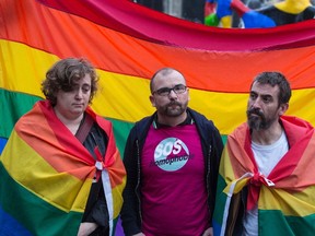 People and a man wearing a T-shirt of French association against homophobia "SOS Homophobie" holding the peace rainbow flag gather for a vigil near the Beaubourg art center in downtown Paris on June 12, 2016, to mourn for victims of the mass shooting that occured overnight in Orlando, Florida, at the Pulse gay nightclub. Fifty people were killed, in addition to the shooter, and 53 wounded in the worst mass shooting in US history, the mayor of Orlando Buddy Dyer said earlier on June 12. A fighter from the Islamic State group carried out the mass shooting, the IS-linked news agency Amaq said, quoting an unidentified source. (AFP PHOTO / GEOFFROY VAN DER HASSELT)
