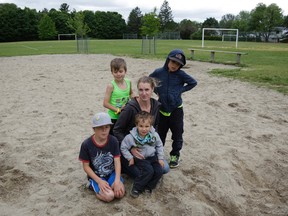 Karen Adelberg with her children at the Leslie Park school playground. Adelberg spent hours raising money for a new play structure. (David Kawai, Postmedia Network)