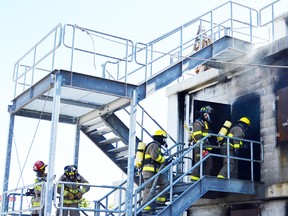 Firefighters train on a Sunday morning at Lambton College Fire School, where they fought fires and performed search and rescue drills in the concrete buildings on site. (Melissa Schilz/Postmedia Network)