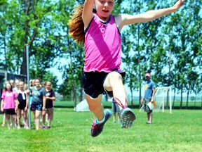 Rachel Reath Dobson takes a running leap during the junior girls running long jump event at St. Columban School's Track and Field day June 2. GALEN SIMMONS MITCHELL ADVOCATE