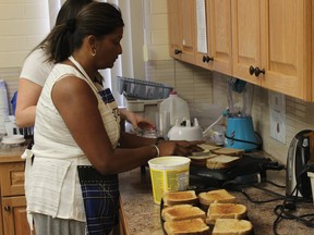 Canyon School teacher Savi Houldin prepares grilled-cheese sandwiches for students during Friday’s breakfast club. The school’s staff served over 1,200 meals this year.