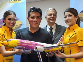 Patee Sarasin (centre L), CEO of Nok Air, poses next to John Wojick (centre R), senior vice president, Global Sales for Boeing Commercial Airplanes, during a press announcement at the Singapore Airshow on Feb. 12, 2014.  (AFP PHOTO/ROSLAN RAHMAN)