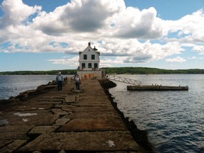 This Aug. 18, 2014 photo shows people walking on the Rockland Breakwater, a man-made granite jetty that stretches nearly a mile into Penobscot Bay from Rockland, Maine. A stroll on the jetty to the lighthouse at the other end almost feels like you're walking on water. For visitors looking to experience Maine's coast, Rockland offers scenery, the arts and good local restaurants. (AP Photo/Beth J. Harpaz)