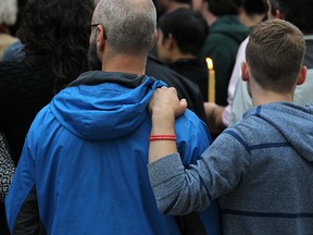 Attendees show support for the victims in Orlando, Fla., during a vigil at the Rainbow Resource Centre on Scott Street on Sunday night. The wristband reads Report Homophobic Violence, Period. (Kevin King/Winnipeg Sun)