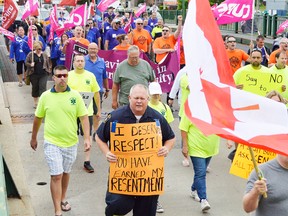 Paramedics, union members, and supporters on Monday marched in protest of a new plan to merge Fire and EMS services after their current contract expires at the end of 2016. Over 200 people attended the rally, many from outside of Chatham-Kent. They see the municipality as the possible pilot project for an integrated Fire and EMS service and want to make sure that doesn't happen across Ontario. (Louis Pin/Postmedia Network)
