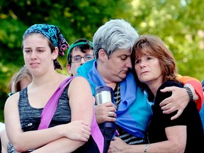 Aidan Wood, left, her mother, Lisa Laughman and Karen Pace console each other at a vigil for the mass shootings in Orlando, Fla., in Lansing, Mich., Sunday, June 12, 2016. (Robert Killips/Lansing State Journal via AP)