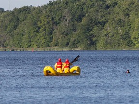 Rescuers paddle to rescue two men whose canoe capsized in the Cataraqui River on Monday evening. One man was able to swim to shore while the other needed to be rescued by emergency personnel. (Julia McKay/The Whig-Standard)