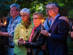 Ontario Premier Kathleen Wynne and her wife Jane Rounthwaite hold a candle during a vigil at Barbara Hall Park on Sunday for those killed in the Orlando club massacre. (ERNEST DOROSZUK, Toronto Sun)