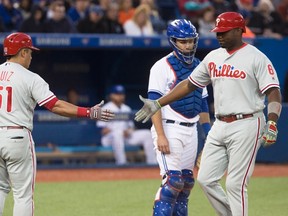 Philadelphia Phillies' Ryan Howard is congratulated by teammate Carlos Ruiz after hitting a solo home run as Toronto Blue Jays catcher Josh Thole looks on during seventh-inning action at the Rogers Centre in Toronto on June 13, 2016. (THE CANADIAN PRESS/Chris Young)