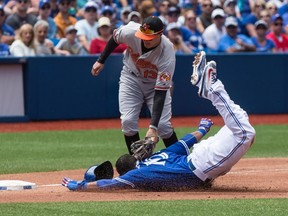 According to Blue Jays manager John Gibbons, Edwin Encarnacion jammed his right index finger on this play Sunday when he stole third base against Baltimore. (CHRIS YOUNG/The Canadian Press)